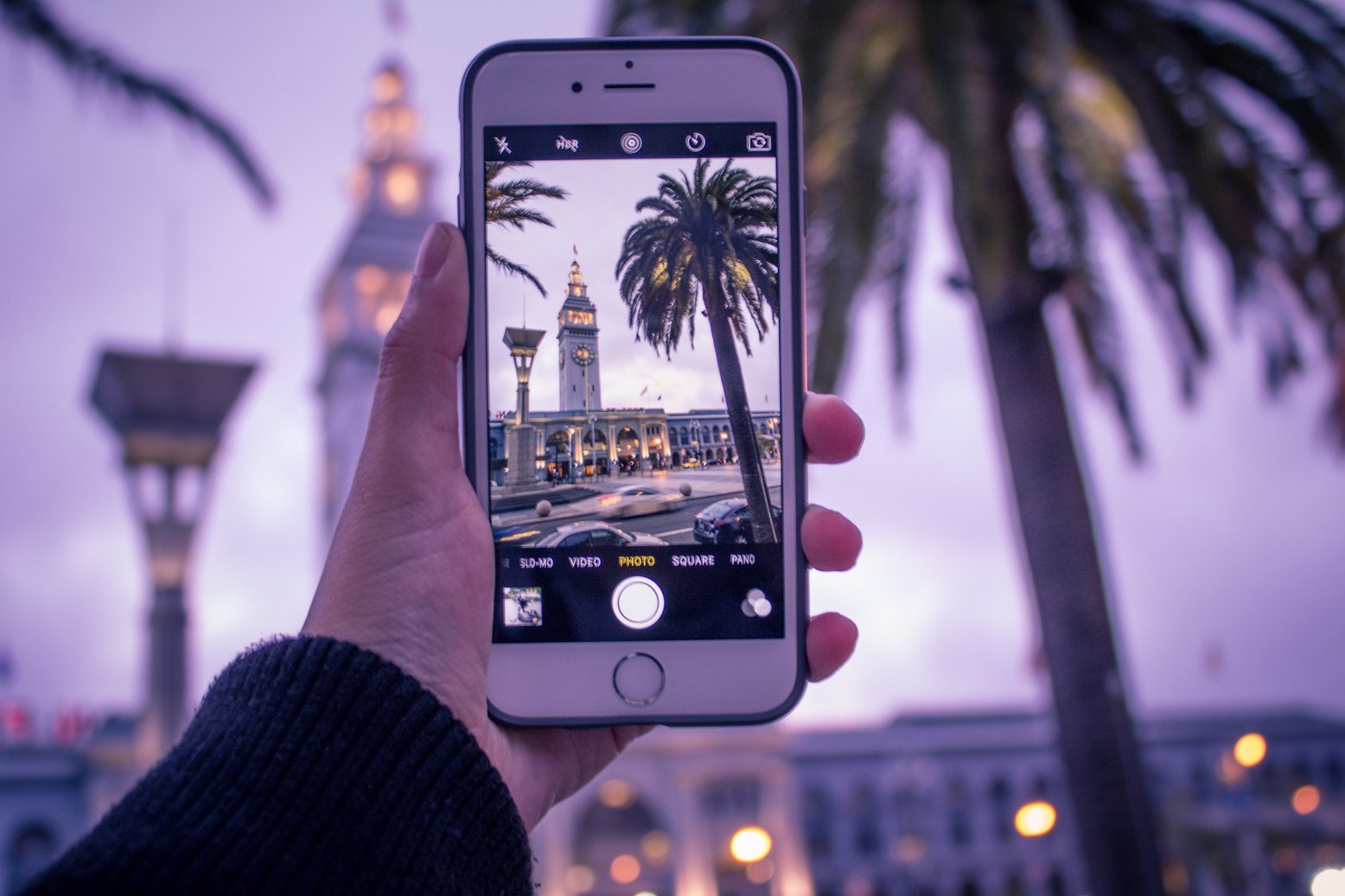 Man Taking a Photo of a Clock Tower